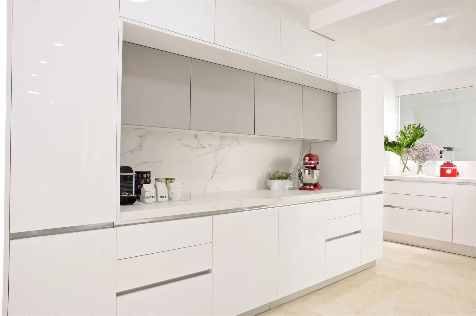 Cocina blanca con gabinetes de nicho y topes de mármol