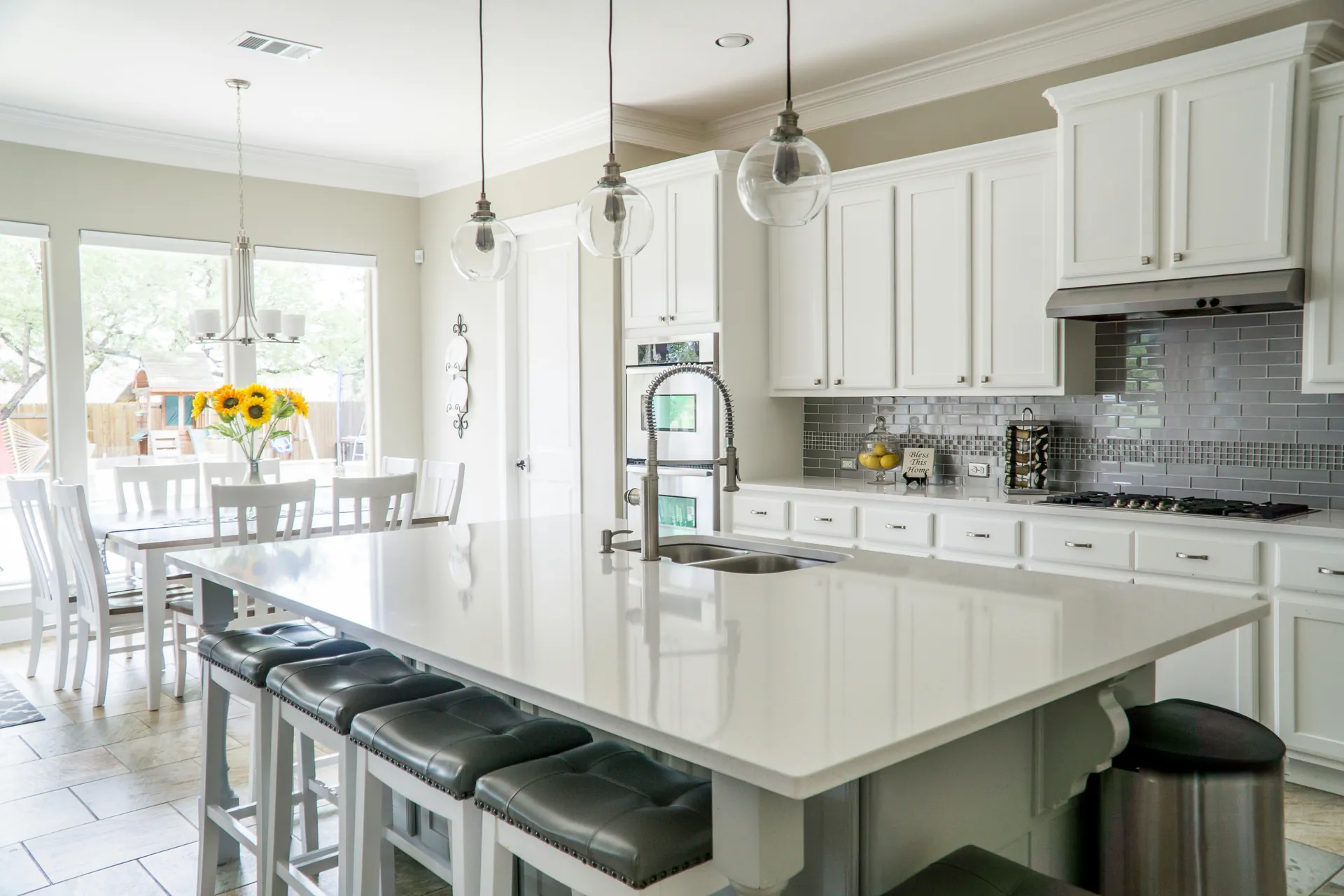 White shaker kitchen with dark island and stainless appliances