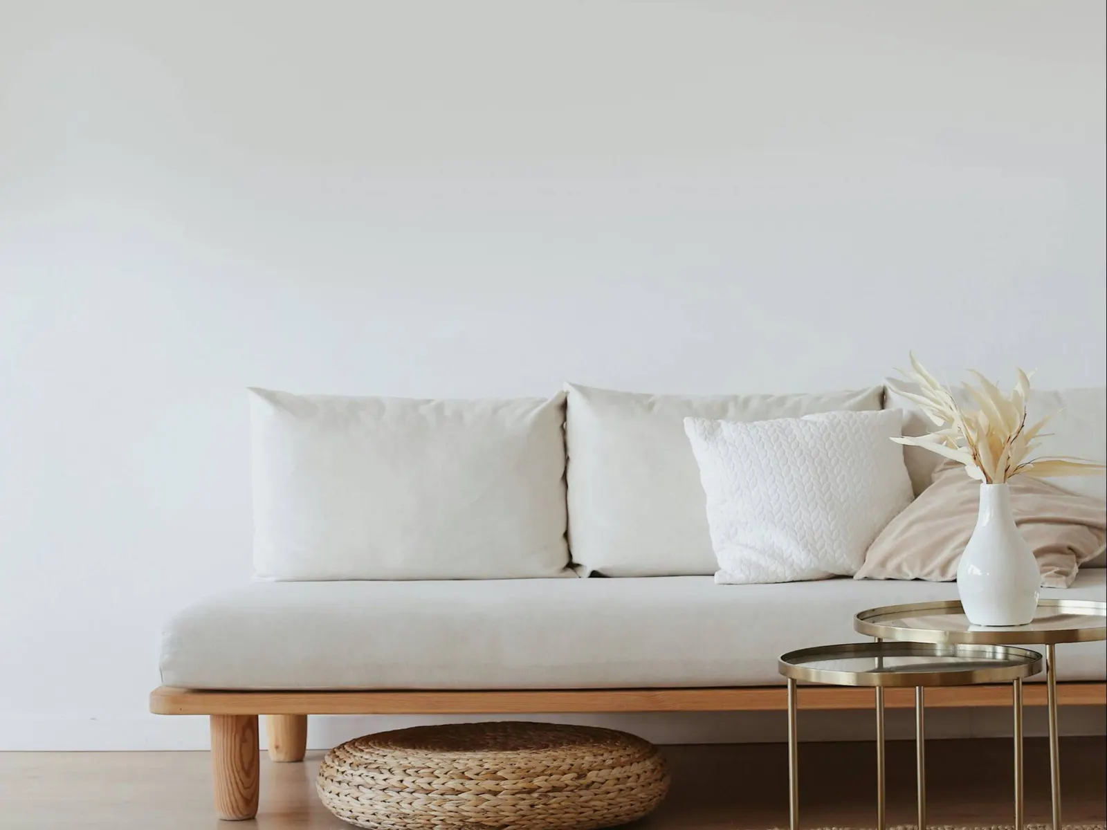 Living room with light gray sofa, patterned pillows, and black side tables